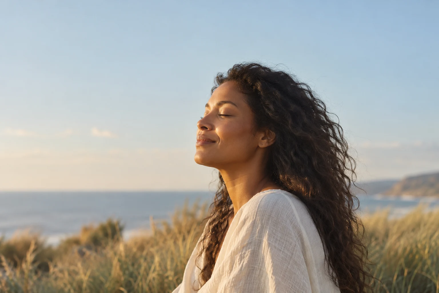 A woman enjoying a quiet moment outdoors by the coast